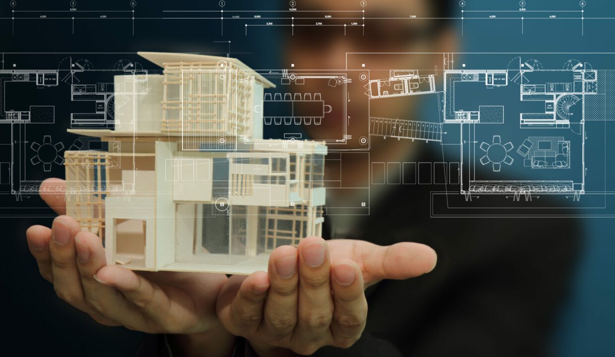 Manholding A Model Of A House In His Hands.